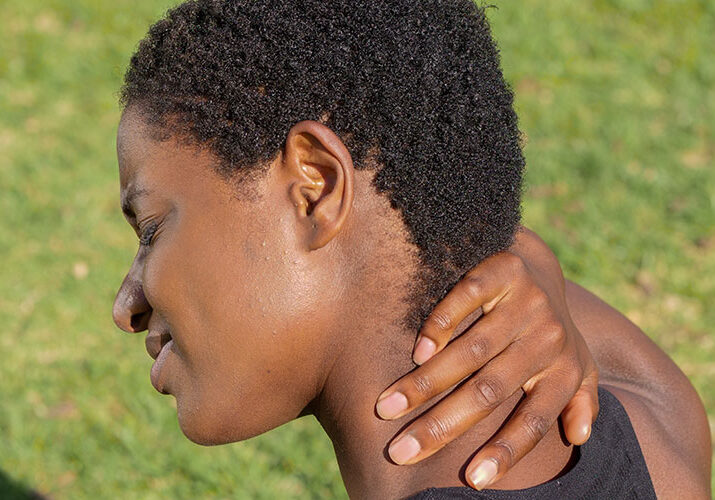 black boy holding his neck in pain