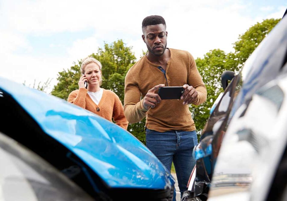 a man taking picture of the car crash